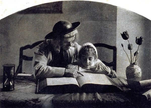 A young man and a little girl in seventeenth century dress, seated at a table reading the Bible