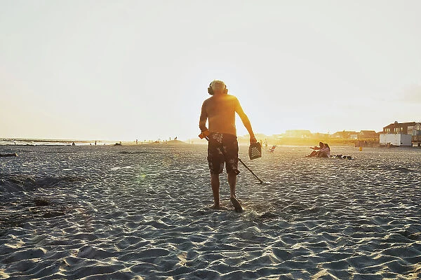 New York, Long Island, Long Beach, Man with metal detector beachcombing