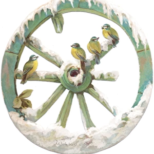Blue tits perched on a wheel on a cutout Christmas card