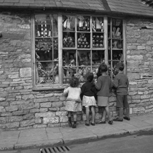 Four children gazing through shop window