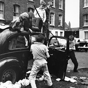 Children playing with a car in a Balham street, SW London