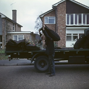 Coalman delivering coal in a street of houses