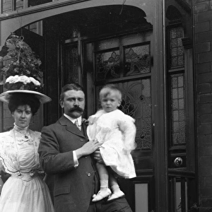 Elegant Edwardian couple with child outside house