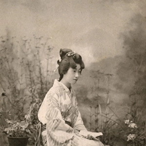 Japanese Geisha seated on a bench