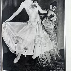 Jean Rai, cabaret performer, theatrical portrait in satin gown, with doll. Captioned, A Rai of Sunshine'. With description, Miss Jean Rai