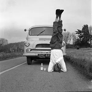 Man standing on his head in the road