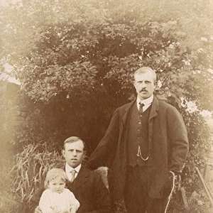 Two men, a little girl and a dog in a garden