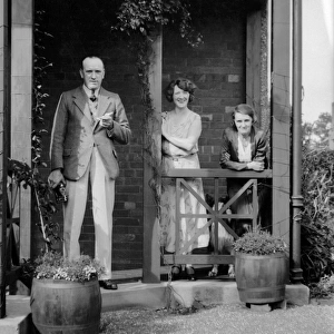 Three people outside a house