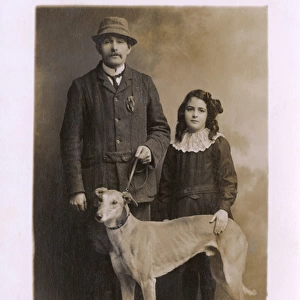 Studio portrait, father and daughter with greyhound