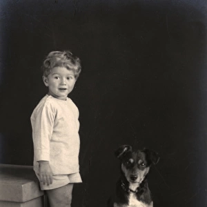 Studio portrait, little boy with puppy