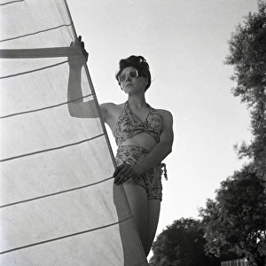 Woman on St Ives beach with yacht sail