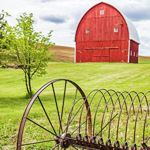 Albion, Washington State, USA. Red barns and antique farm equipment in the Palouse hills. (Editorial Use Only) Date: 23-05-2021