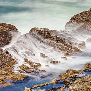 Shore Acres State Park, Oregon, USA. Blur of waves flowing over rocks. Date: 01-05-2021