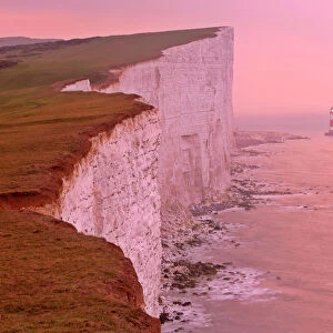 UK - lighthouse at Beachy Head and steep chalk cliffs at sunrise. East Sussex, England, UK