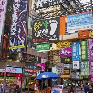 Advertising signs on a busy street in the popular shopping area of Mong Kok (Mongkok)