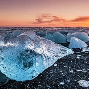 Broken ice from washed up icebergs on Jokulsarlon black beach at sunset, Jokulsarlon