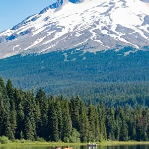 Canoes and rowboat on the still waters of Trillium Lake with Mount Hood, part of the Cascade Range