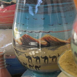 Close up of sand bottles with camels in landscapes