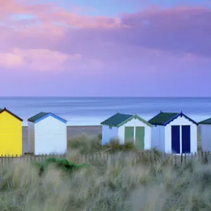 Colourful beach huts and sand dunes at sunset, Southwold, Suffolk, England, United Kingdom