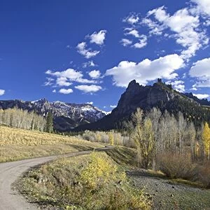 Dirt mountain road with aspens and cottonwoods in fall color