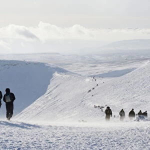 Hikers on snow covered Pen y Fan mountain, Brecon Beacons National Park
