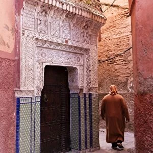 Local man dressed in traditional djellaba walking through street in the Kasbah, Marrakech