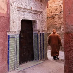 Local man dressed in traditional djellaba walking through street in the Kasbah, Marrakech