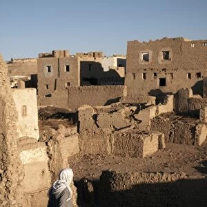 A man stands among the ruin of the mud-brick city of Al-Qasr, Dakhla Oasis