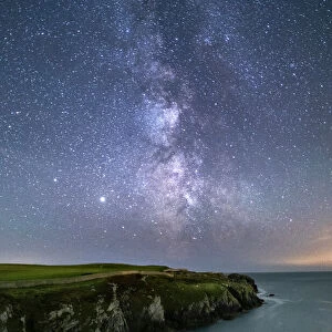 The Milky Way and night sky over Gwenfaens Pillar, Porth Saint, near Rhoscolyn, Anglesey, North Wales, United Kingdom, Europe