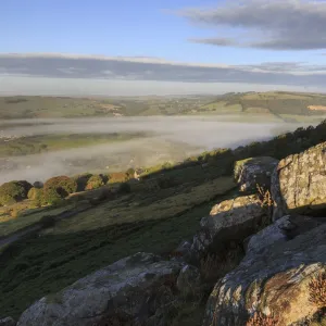 Mist clears from valley, fields and woods, from Curbar Edge at sunrise, autumn dawn