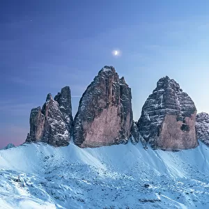 Moon above Tre Cime di Lavaredo at dusk, winter time, Tre Cime di Lavaredo (Lavaredo peaks) (Drei Zinnen), Sesto (Sexten), Dolomites, South Tyrol, Italy, Europe