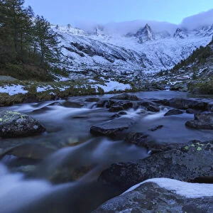 Mountain torrent at dusk in front snowy mountains, Valmasino, Valtellina, Lombardy, Italy, Europe