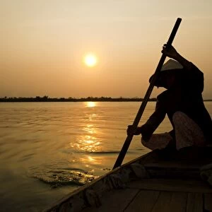 Old lady rowing in Hoi An harbour silhouetted at sunset, Vietnam, Indochina, Southeast Asia, Asia