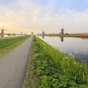 Panorama of the typical windmills reflected in the canals at dawn, Kinderdijk, UNESCO