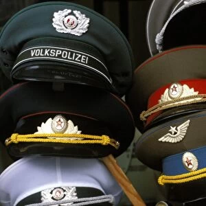 A pile of Communist era army and police hats for sale as souvenirs