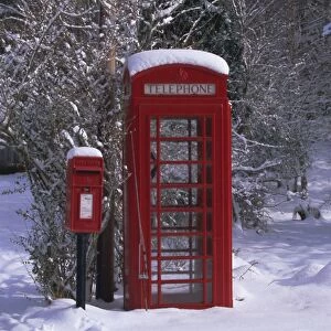 Red letterbox and telephone box in the snow