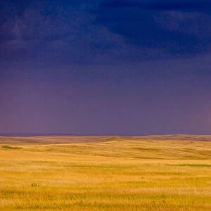 Rolling plains against a dark stormy sky in the Badlands, South Dakota