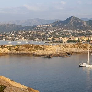 A sail boat in the clear sea around the village of Ile Rousse at sunset, Balagne Region