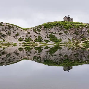 The small church and the reflection of the alpine landscape in the calm water, Olbe lakes, Sappada, Carniche Alps, Udine province, Friuli-Venezia Giulia, Italy, Europe
