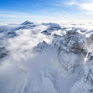 Snow capped Monte Pelmo emerging from clouds, aerial view, Dolomites, Belluno province