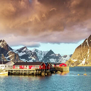 Storm clouds at dawn over mountain peaks and fishing village of Sakrisoy, Reine, Nordland county, Lofoten Islands, Norway, Europe