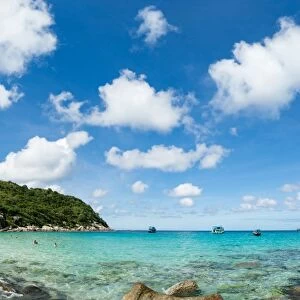 Toursits enjoy the clear water and sun at a beach on the Thai island of Koh Tao, Thailand