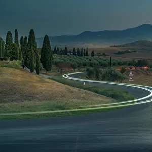 View of car trail lights in Tuscan landscape near Pienza at dusk, Pienza, Province of Siena, Tuscany, Italy, Europe