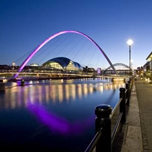 View along Newcastle Quayside at night showing the River Tyne, the floodlit Gateshead Millennium Bridge, the Arched Bridge and the Sage Gateshead, Newcastle-upon-Tyne, Tyne and Wear, England, United