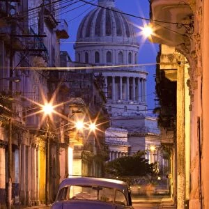 Vintage American car parked on floodlit street with The Capitolio in the background, predawn, Havana Centro, Cuba, West Indies, Central America