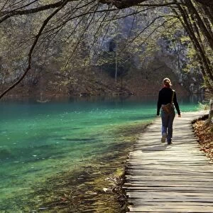 Visitor on wooden walkway path over Crystal Clear Waters of Plitvice Lakes National Park, UNESCO World Heritage Site, Plitvice, Croatia, Europe