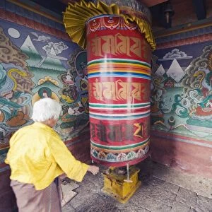 A woman spinning a prayer wheel, Chimi Lhakhang dating from 1499, Temple of the Divine Madman Lama Drukpa Kunley