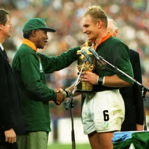 Francois Pienaar receives the Webb Ellis Cup from Nelson Mandela