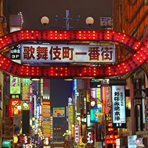 Night street scene of illuminated signs and lights of shops in Shinjuku, Tokyo, Japan