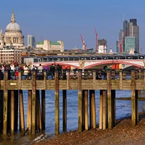 Wooden pier at Oxo Tower Wharf on the River Thames with Blackfriars Bridge and the City of London skyline in London, England